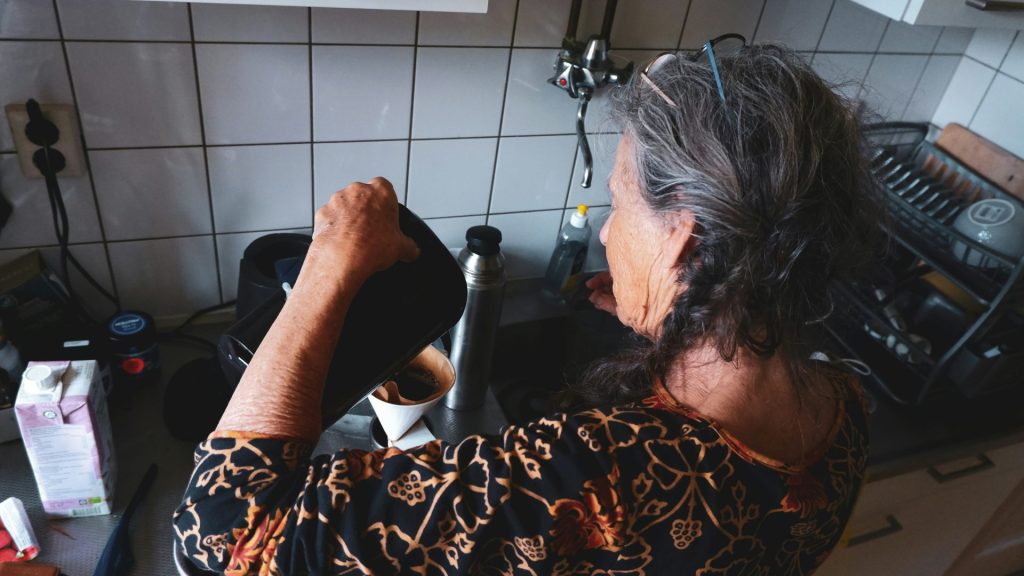 a person with long hair sitting in front of a stove